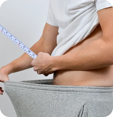 Man measuring his midsection with a tape measure, used to illustrate body and personal confidence concerns alongside Soda Peak messaging